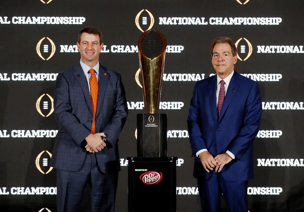 Clemson head coach Dabo Swinney, left, and Alabama head coach Nick Saban pose next to the College Football Playoff national championship trophy. (UA Athletics)