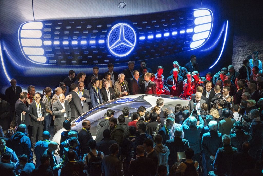 Daimler CEO Dieter Zetsche is surrounded by attendees and members of the media at the unveiling of the Mercedes-Benz F015 self-driving concept vehicle at the 2015 Consumer Electronics Show. Daimler and Uber have announced a deal to jointly pursue the autonomous technology. (David Paul Morris/Bloomberg)