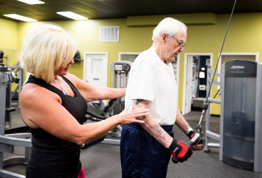 Personal Trainer Meadows (left) advises Gilliland during a workout.