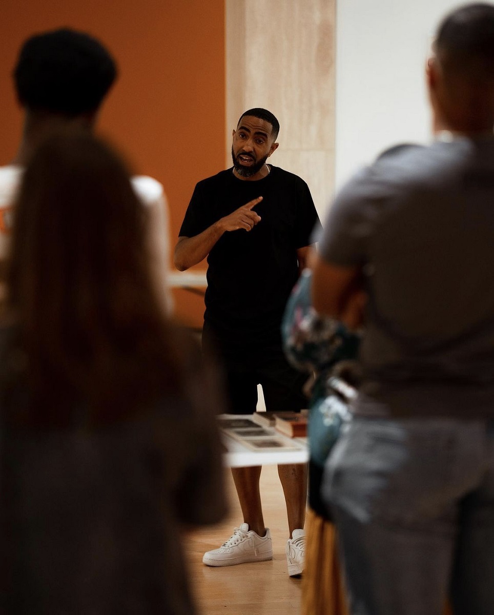 Khalil Kinsey, general manager and chief curator of collection and exhibitions for “The Kinsey Collection,” shares objects with members of the museum’s student advisory board during installation. (contributed)