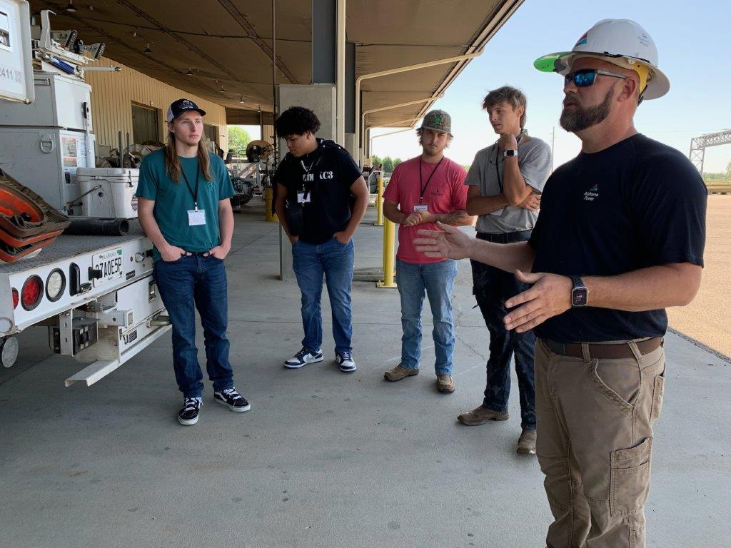 Students at Headland career day hear from James Tucker, right, local operation lineman for Alabama Power, during a warehouse tour. (Teisha Wallace / Alabama News Center)
