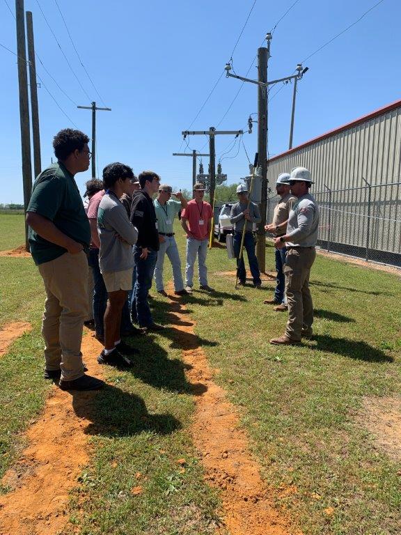 Lineman Brandon Dean, Distribution Specialist Todd Marchman and Lineman Steven Parker discuss electrical circuits at Headland Lineworker Career Day. (Teisha Wallace / Alabama News Center)