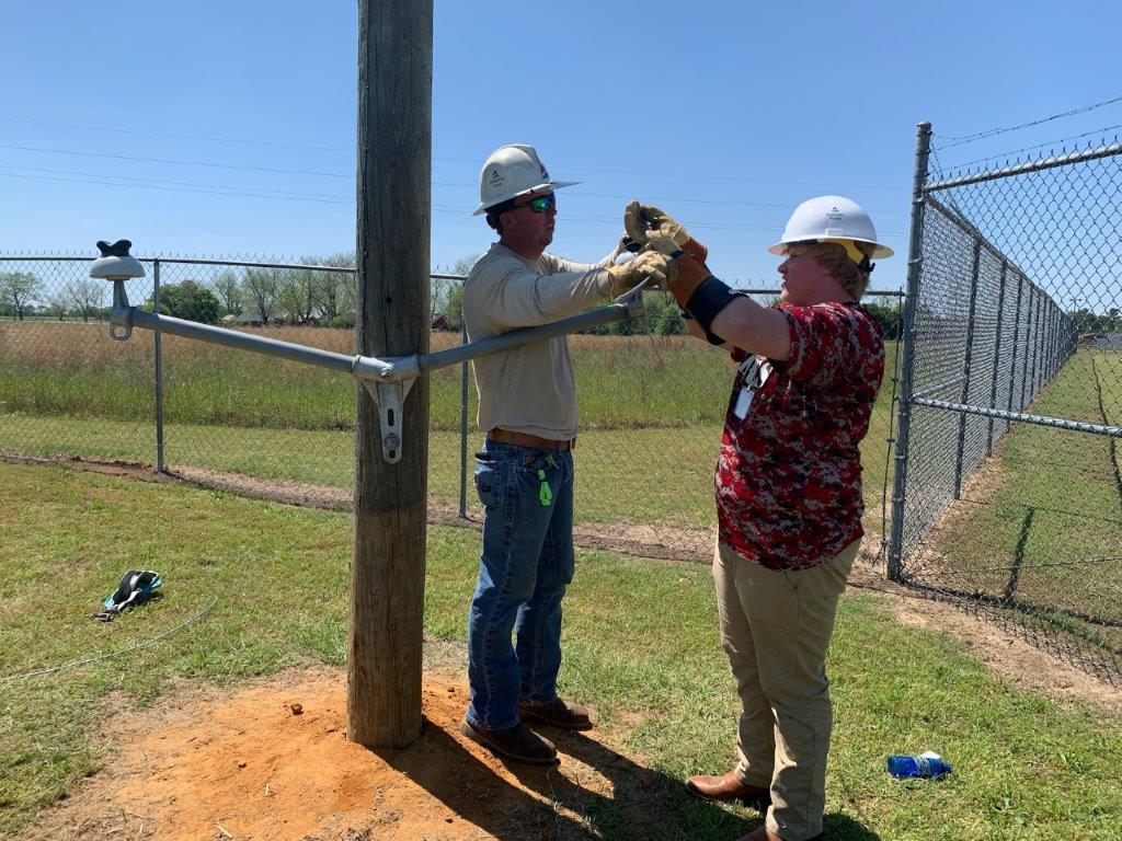 Alabama Power Lineman Bradley Dean, left, walks a student through an interactive demonstration about power line work at Headland career day. (Teisha Wallace / Alabama News Center)