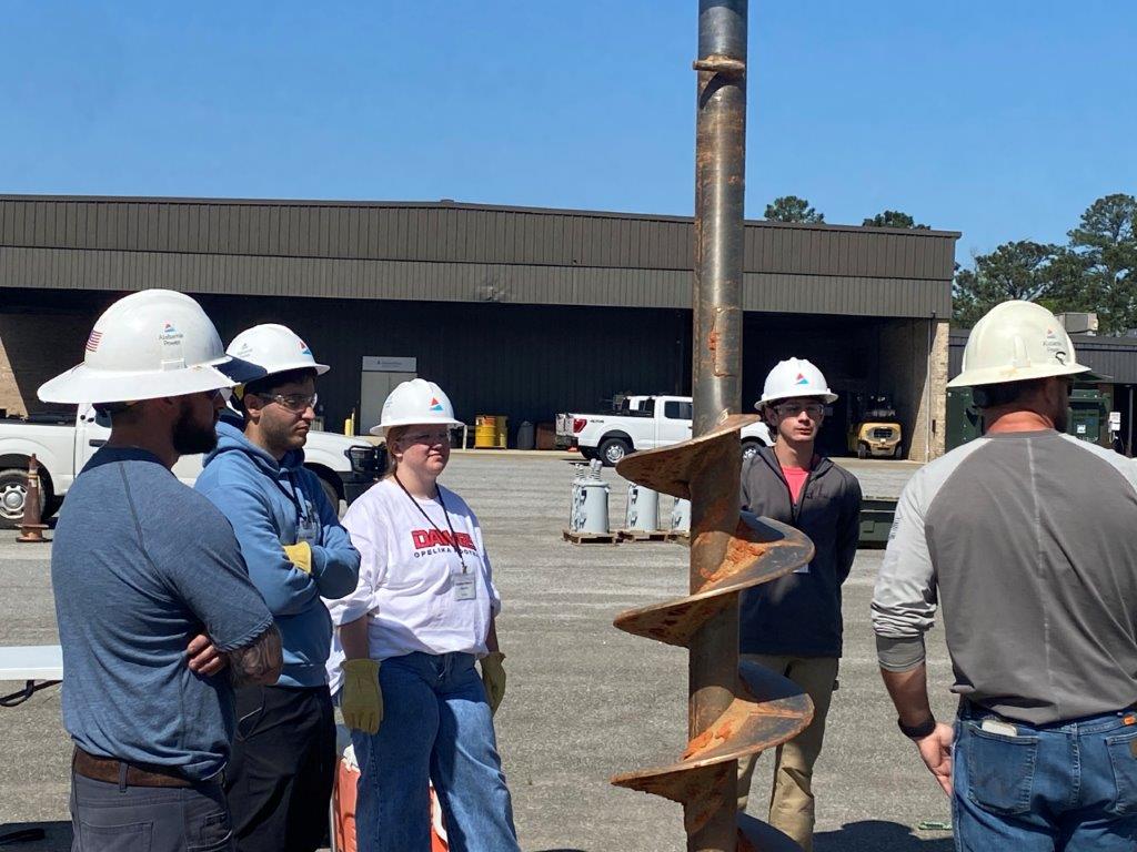 Lineman Caleb Freeman, far left, and Lineman Clay Huckaby, far right, educate students during the Phenix City Lineworker Career Day. (Brooke Goff / Alabama News Center)